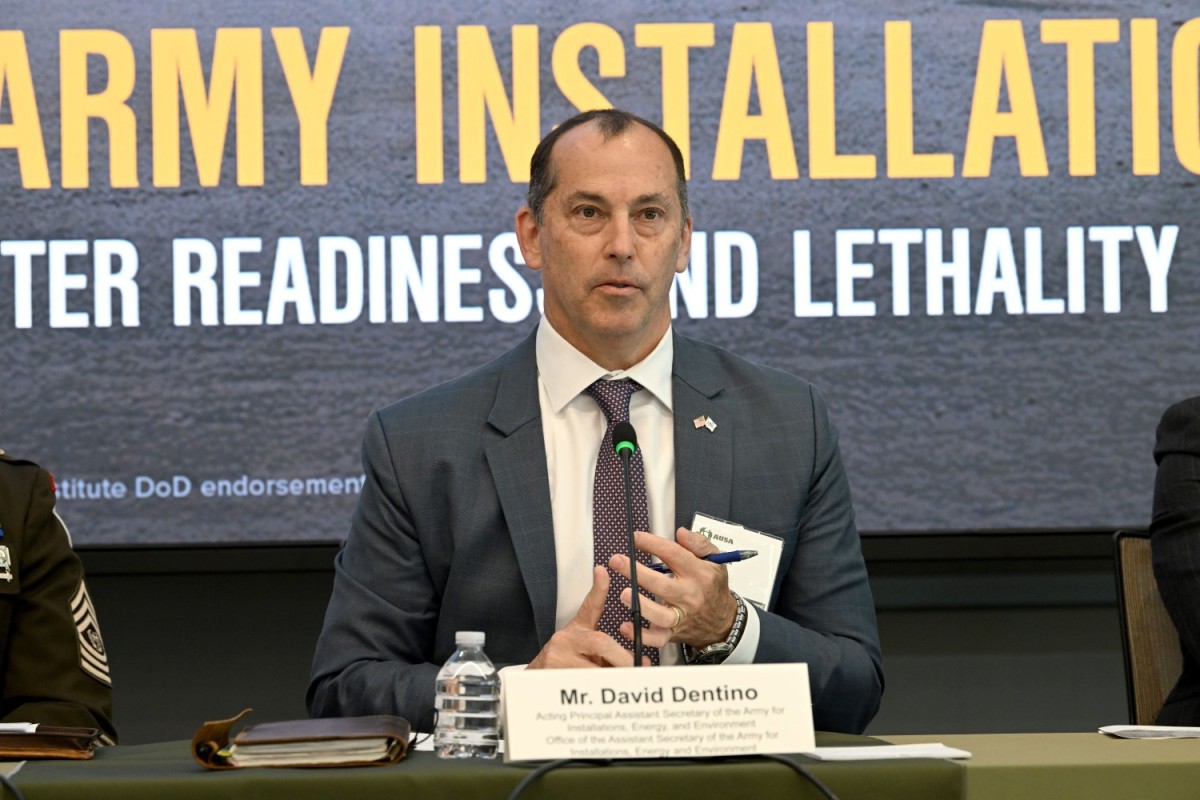 image of a speaker at a podium next to a soldier