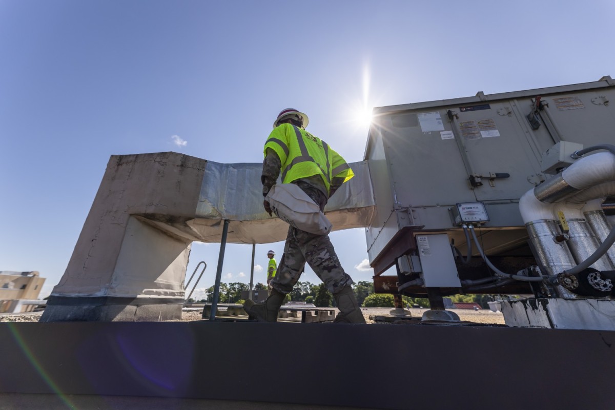 image of a construction man walking alongside a machine