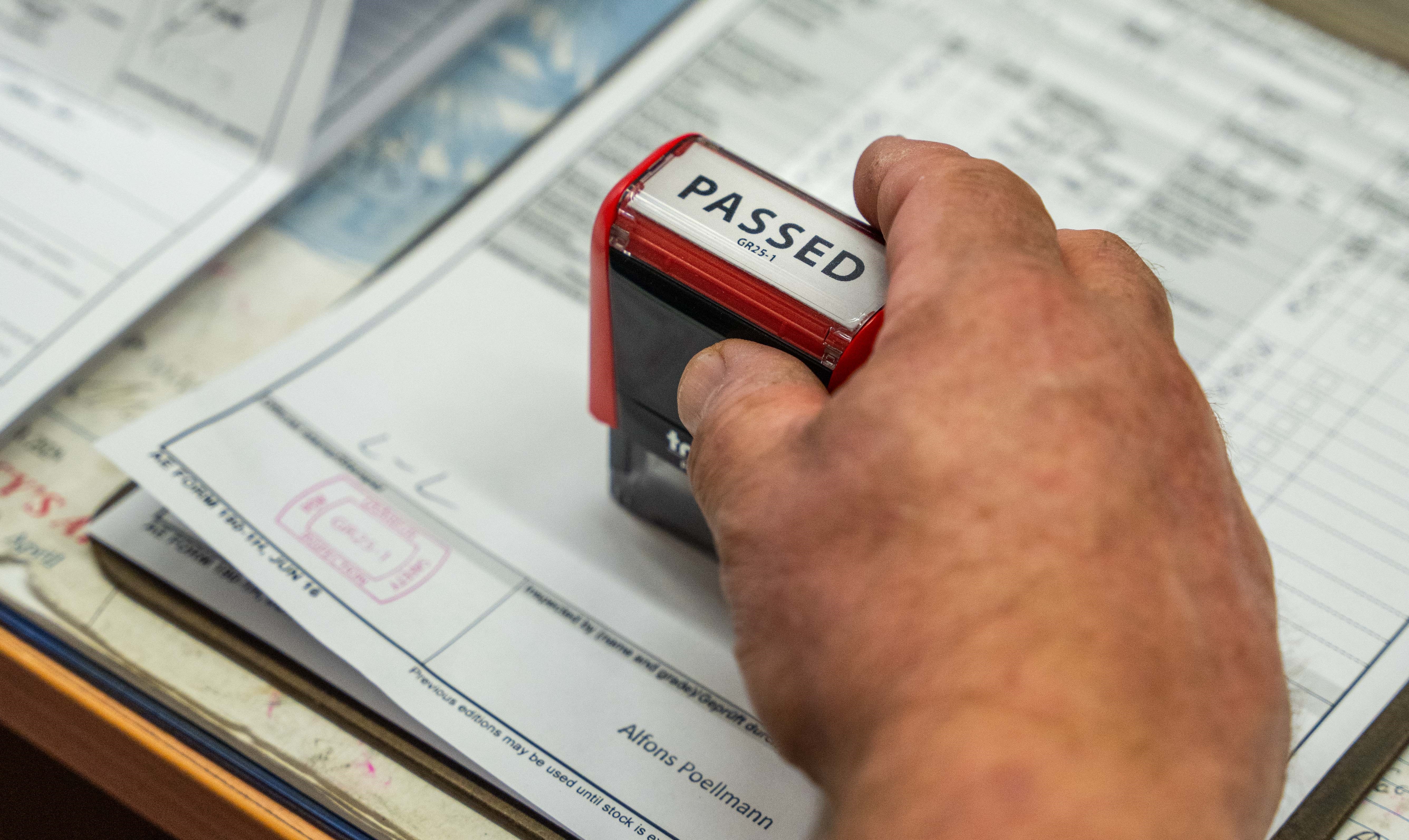image of someones vehicle inspection being stampped as a pass